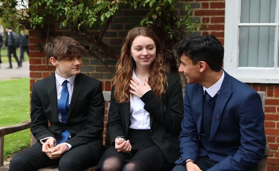 Students conversing on bench